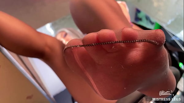 Goddess sexy feet close-up in torn sweaty nylons on the table